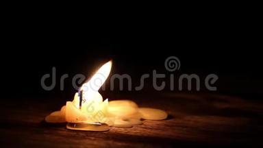 美丽的燃烧蜡烛，火焰从灯芯和蜡光进入黑暗的木桌背景与复制空间f。